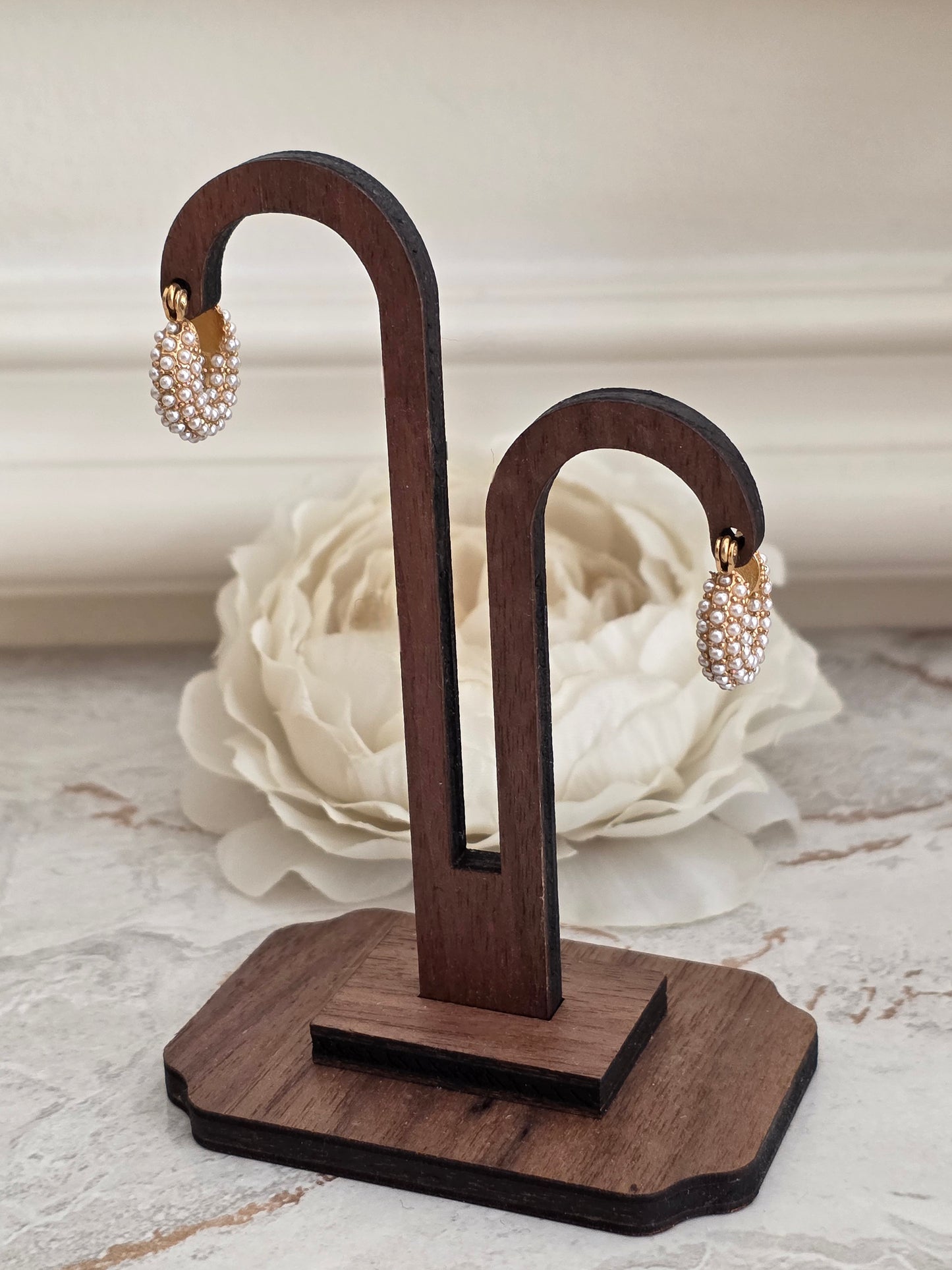 Gold pearl huggie hoop earrings covered in small clustered pearls