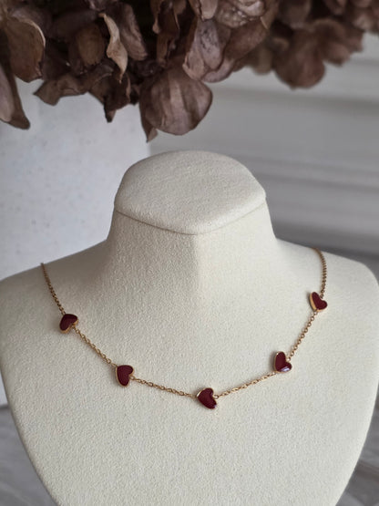 gold necklace with red enamel hearts