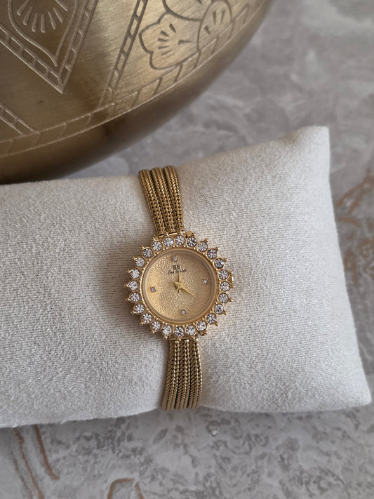 Alessia Watch featuring a gold-tone stainless steel multi-strand band, champagne-toned round dial and sparkling crystal detailing around the watch face.