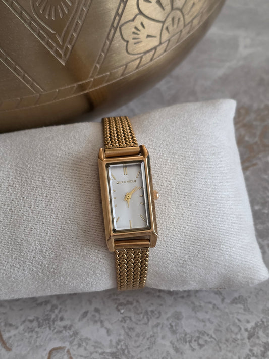Gold Layan Watch featuring a rectangular champagne-toned dial, slim woven stainless steel gold-plated band and adjustable wrist fit.