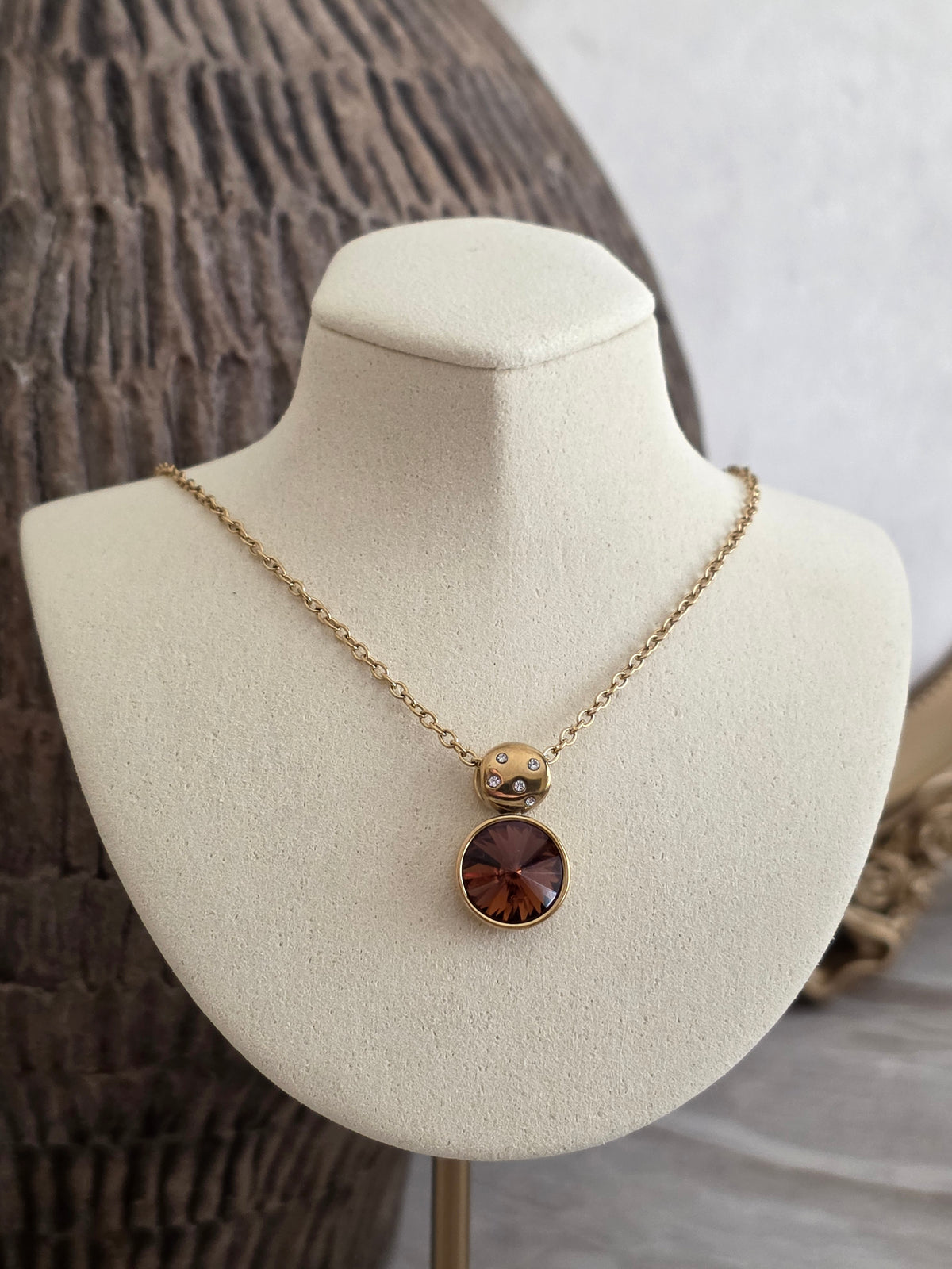 Meral Necklace with gold chain, sparkling stone accents and a round amber-brown faceted crystal pendant.