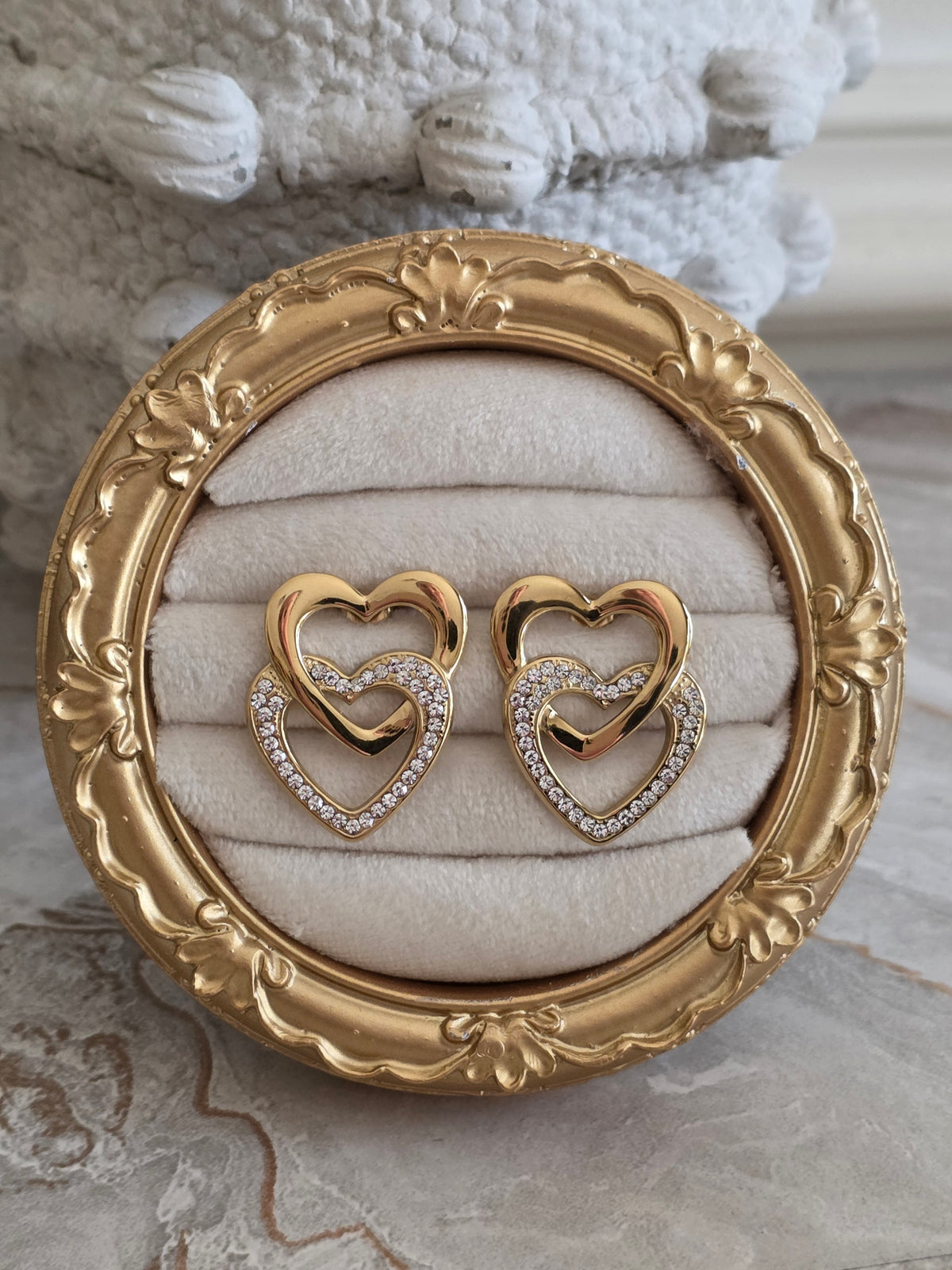 Liana Heart Earrings featuring intertwined gold hearts with sparkling crystal embellishments.