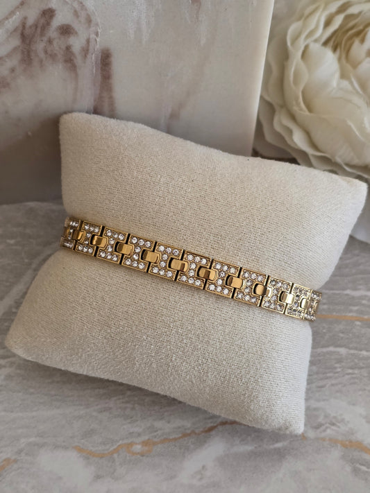 Gold Zariah Bracelet featuring geometric links with sparkling crystal detailing, displayed on a beige jewellery cushion.