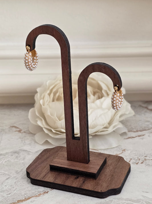 Gold pearl huggie hoop earrings covered in small clustered pearls