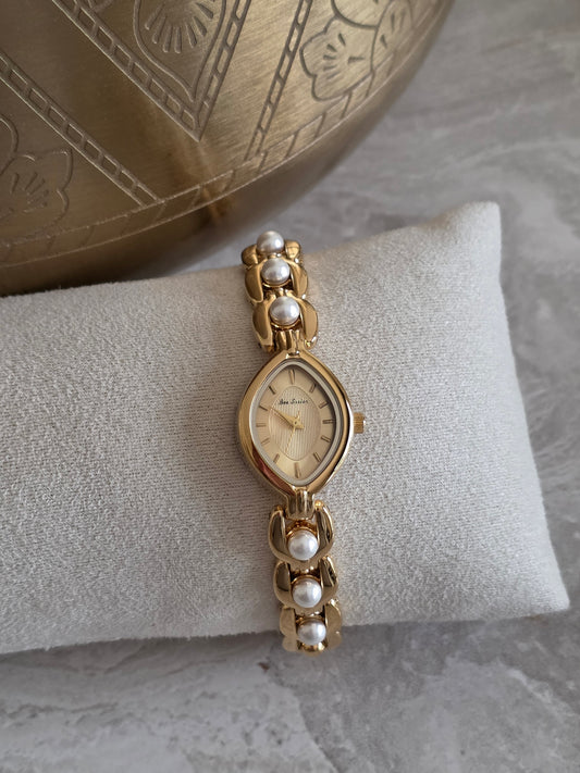 Naz Pearl Watch featuring a gold-tone stainless steel bracelet with elegant pearl detailing and a champagne-toned marquise-shaped watch face.