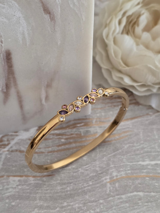 Lilayda Bangle in polished gold with pink, purple and clear crystal stones in mixed shapes.
