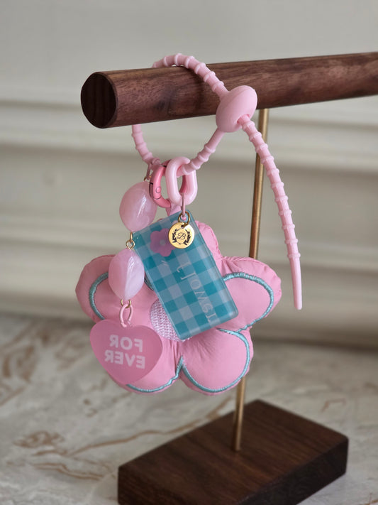 Cute pink flower keychain with heart-shaped charm that says “Forever,” pastel beads, and a blue gingham tag