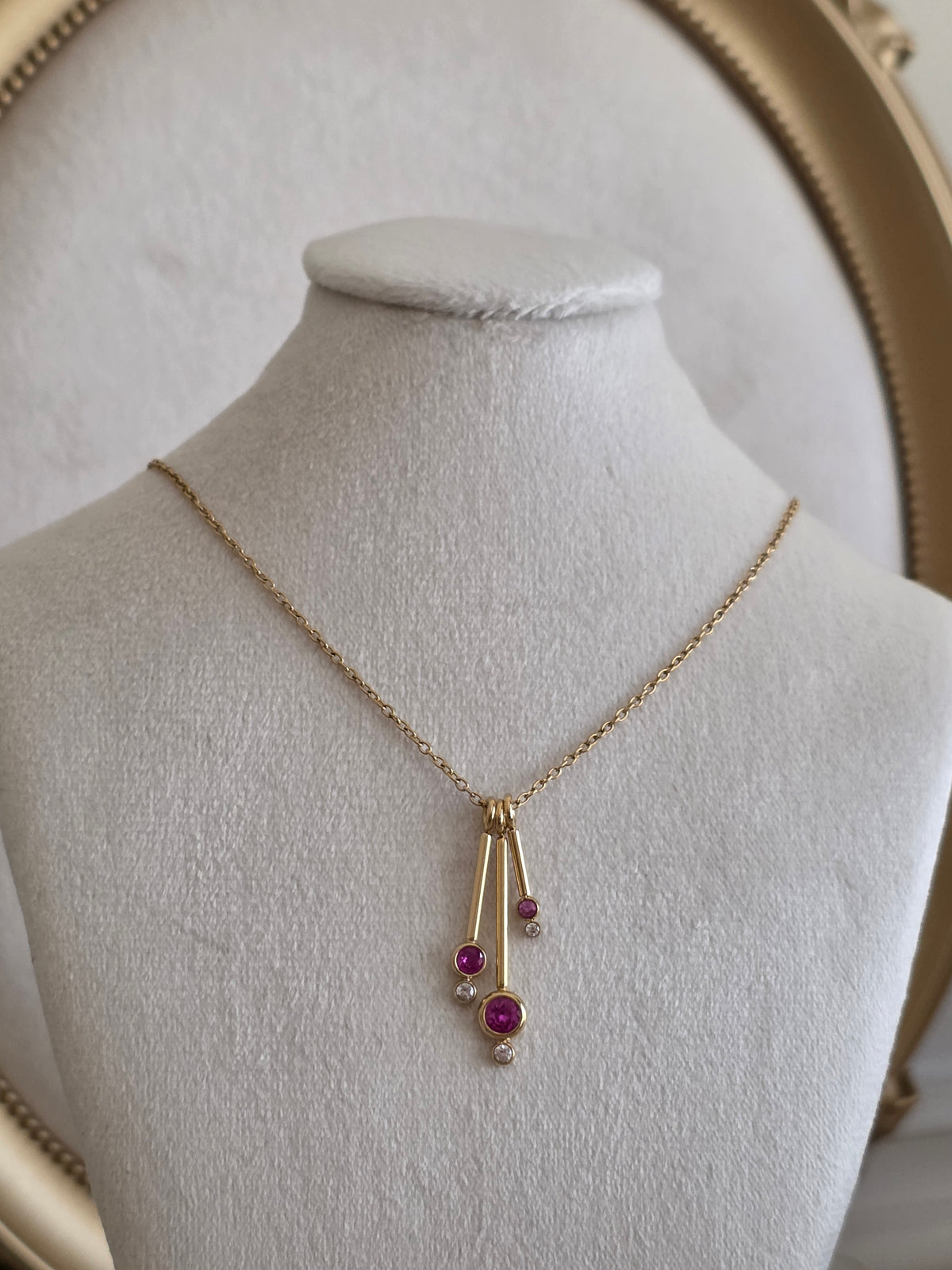 Aliyna Necklace featuring a delicate gold chain with three pink stone drops and sparkling clear crystal accents.