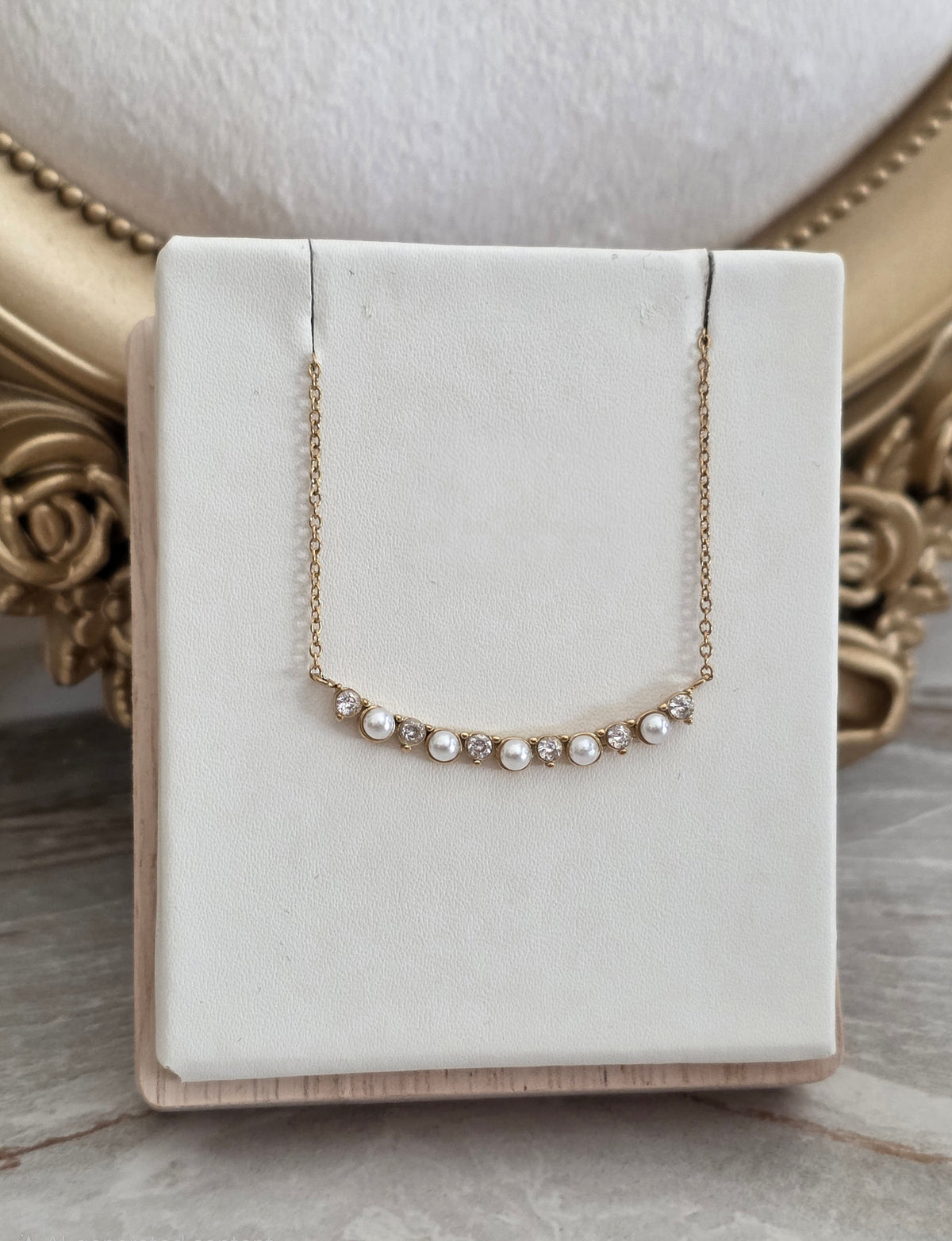 Ferda Pearl Necklace featuring pearl-inspired accents and sparkling crystal stones on a delicate gold chain.