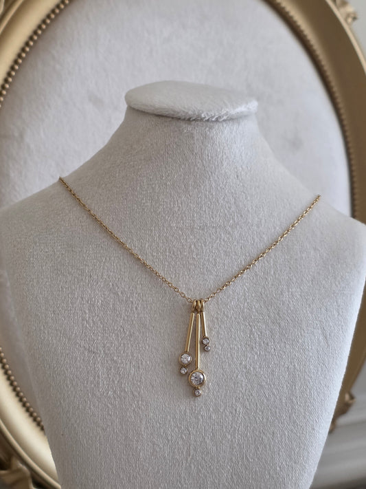 Aliyna Necklace featuring three elegant gold drop pendants with sparkling crystal stones on a delicate gold chain.