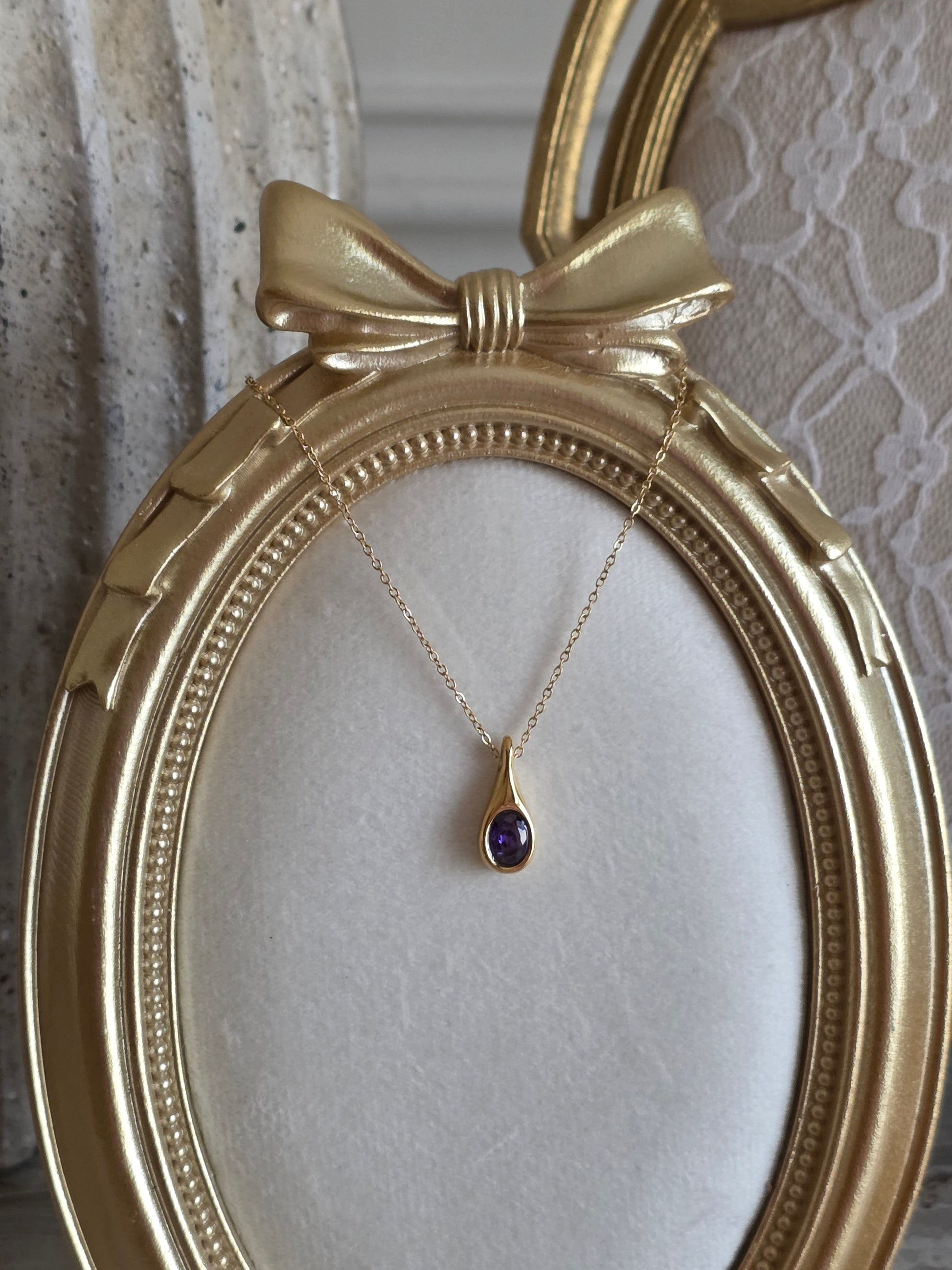 Gold pendant necklace with purple cubic zirconia crystal