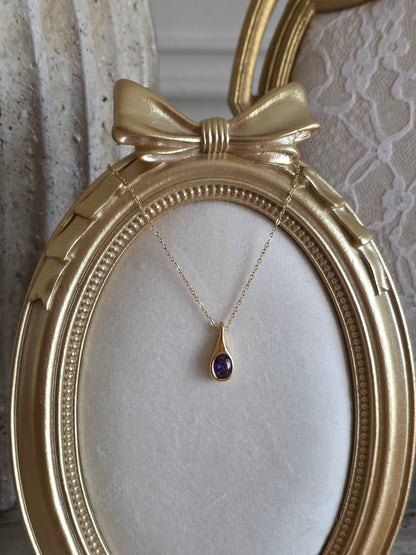 Gold pendant necklace with purple cubic zirconia crystal
