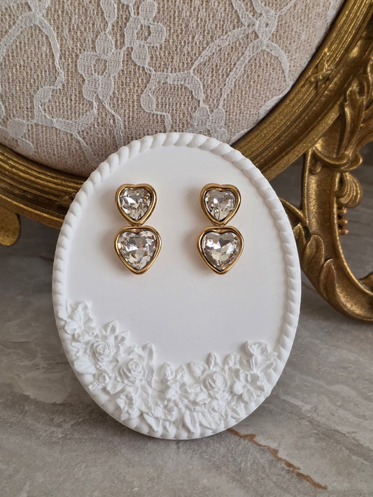 Gold-tone Ladia Heart Earrings featuring double heart-shaped faceted crystal inserts in an elegant drop design.